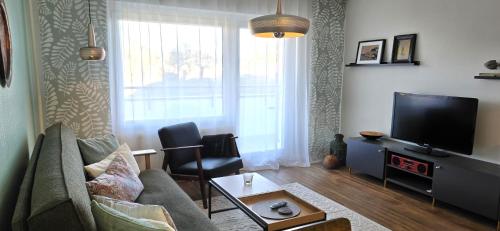 a living room with a couch and a flat screen tv at Haus Nordland Wg 6 und 7 in Sylt