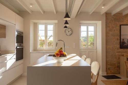 a kitchen with a bowl of fruit on a kitchen island at Siavo Junto a la Ría in Outes
