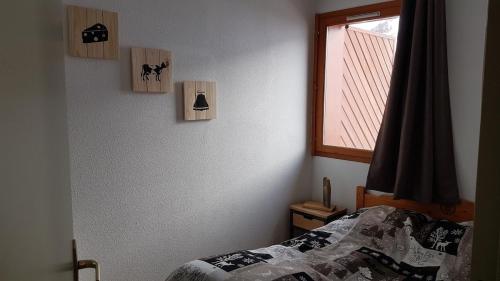 une chambre avec un lit et une fenêtre dans l'établissement La sérénité des aiguilles, à Albiez-Montrond