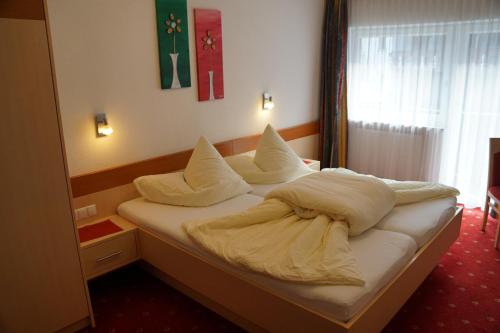 a bedroom with a bed with pillows on it at Apart Felsenhof in Längenfeld