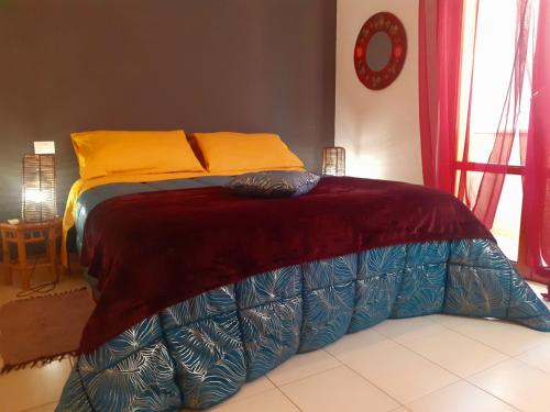 a bed with orange and blue sheets on top of it at Casa Dellestate in Grottammare