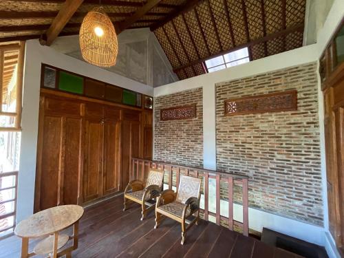 a balcony of a house with chairs and a table at Saka Homestay Boutique & Cafe in Borobudur