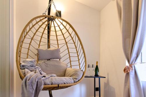 un fauteuil suspendu dans une chambre avec fenêtre dans l'établissement love room Evasion, à Tuchan