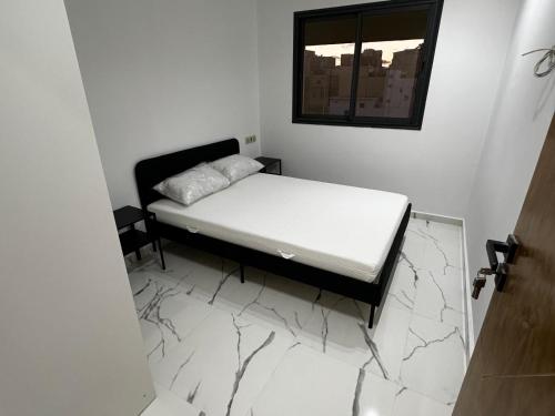 a small bedroom with a bed and a mirror at Abdel in Martil