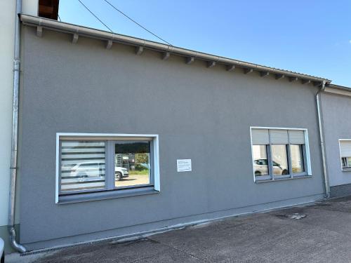 a gray house with two windows on the side of it at Moderne FerienWohnung NeuBau Merzig in Merzig