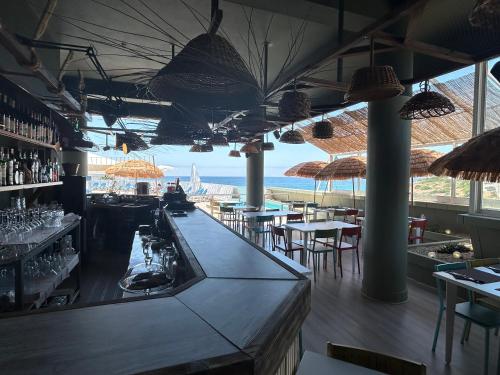 a restaurant with a bar with a view of the ocean at Magnolia Mar Apartamentos in Lagos
