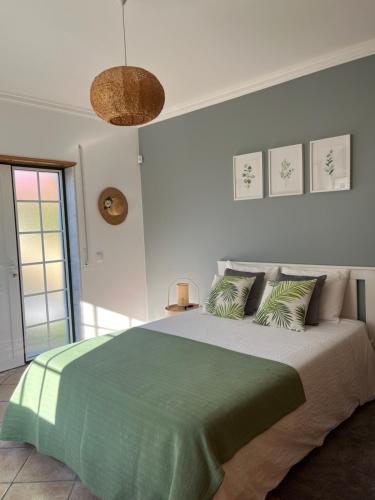 a bedroom with a large bed with a green blanket at Ocean Country Guest House Freiria in Freiria