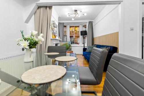 ロンドンにあるAmazing House Stratford Londonのテーブル2つとソファのあるリビングルーム