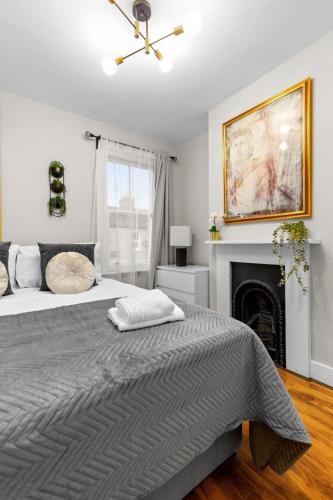 a bedroom with a large bed and a fireplace at Amazing House Stratford London in London