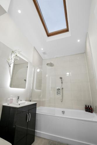 a bathroom with a tub and a sink and a shower at Amazing House Stratford London in London