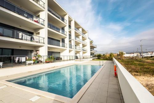 an apartment building with a swimming pool at Wave of happiness in São Martinho do Porto