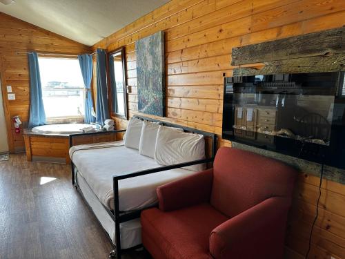 a bedroom with a bed and a couch and a window at Westport Marina Cottages in Westport