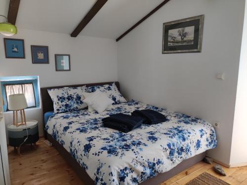 a bedroom with a bed with blue and white sheets at Villa Nono in Vrh