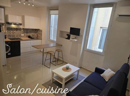 un salon avec un canapé bleu et une table dans l'établissement Studio chic moderne Marseille, à Marseille