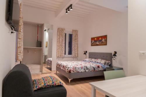 a bedroom with a bed and a chair and a table at L'ANGOLO di GALILEO in Pisa