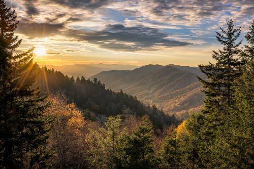 a view of a mountain valley with trees and the sunset at 5 Solas Lodge in Sevierville