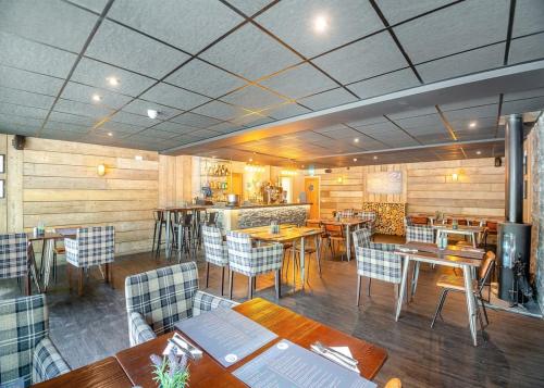 a restaurant with tables and chairs and a bar at Ogwen Bank Caravan And Lodge Park in Bethesda