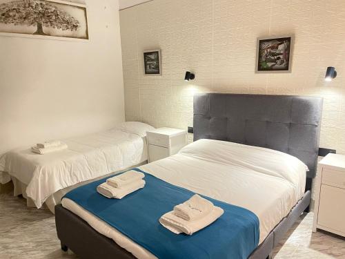 two beds in a room with towels on the bed at Hotel Arganda in Arganda del Rey
