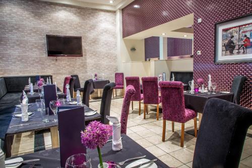 a dining room with tables and purple chairs at Rox Hotel Aberdeen by Compass Hospitality in Aberdeen