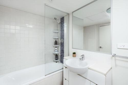 a white bathroom with a sink and a mirror at Great Value CBD 2 Beds Apt Free Carpark Pool and Gym in Brisbane