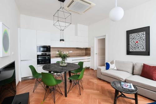 a living room with a table and green chairs at Masarykova N°30 in Brno