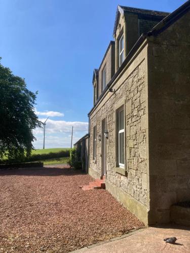 a brick building with a window on the side of it at Marshill Farmhouse in Blackwood