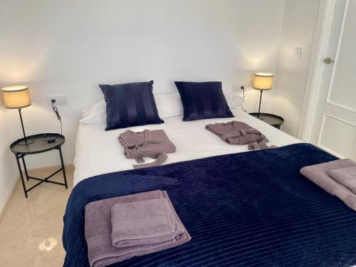 a large bed with blue and white sheets and pillows at La Repera Jaén in Jaén