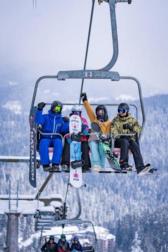 a group of people sitting on a ski lift at Alpine Relax free spa & pool in Pamporovo