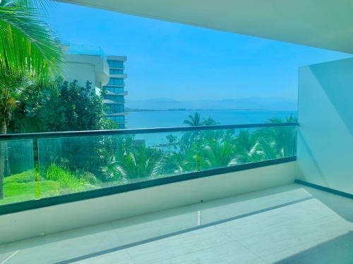 a balcony with a view of the ocean and palm trees at Park Life Narval in Bucerías