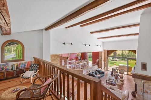 un grand salon avec un escalier et des chaises dans l'établissement La Bastide du Bonrepos, à Bonrepos-Riquet