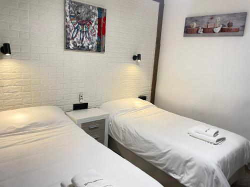 two beds in a small room with white sheets at Hotel Arganda in Arganda del Rey