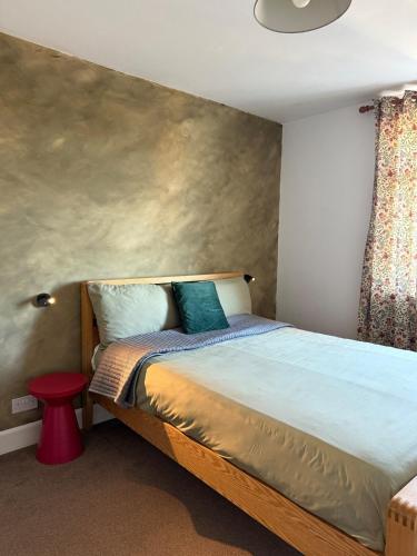 a bedroom with a large bed with a wall at Private Spacious One-Bedroom Flat - Located Between the City Centre and the New Forest in Totton