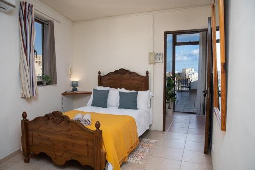una camera da letto con un grande letto con una coperta gialla di Seafront 4-Bed Townhouse with Breathtaking Views a Iż-Żlielaq