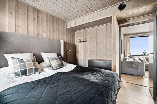 ein Schlafzimmer mit einem großen Bett und einer Couch in der Unterkunft Hafjell Front 8pers Ski InOut in Hunder