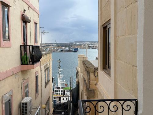a view of the water from between two buildings at Gardjola House by Holi in Senglea