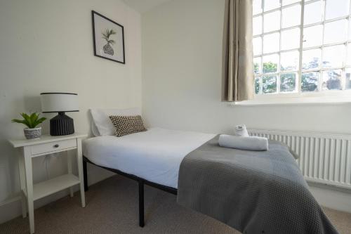 ein Schlafzimmer mit einem Bett und einem Fenster in der Unterkunft 4-Bedroom Central Canterbury Cottage in Kent