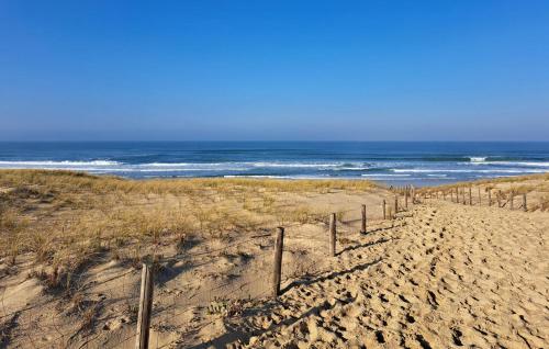 une clôture sur une plage avec l'océan en arrière-plan dans l'établissement Stunning Home In Talais, à Talais