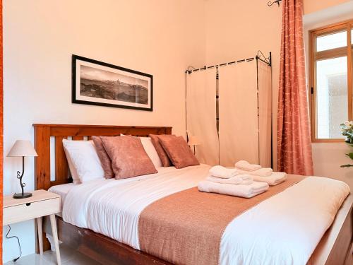a bedroom with a bed with towels on it at Gardjola House by Holi in Senglea