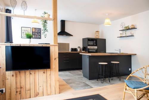 une cuisine avec une grande télévision et un comptoir dans l'établissement Bel appartement entre Campus 1 et Vaugueux, à Caen