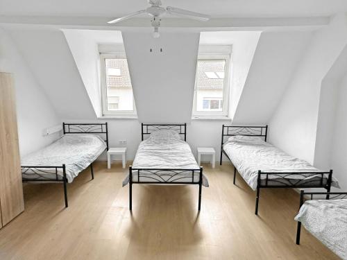 three beds in a room with three windows at Monteurzimmer fitter room Apartment Bruchsal Heilbronn Bretten in Oberderdingen