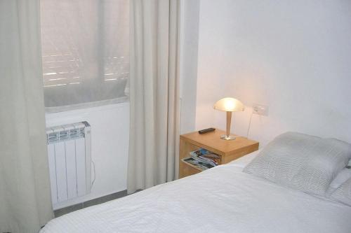 a bedroom with a bed and a window and a lamp at Charming Apartment in Palamós with Sea View and Terrace - 65 sqm in Palamós