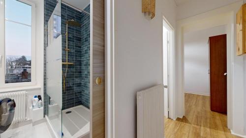 La salle de bains est pourvue d'une douche à l'italienne à côté d'une fenêtre. dans l'établissement Le Majestic & Pool Mulhouse, à Mulhouse