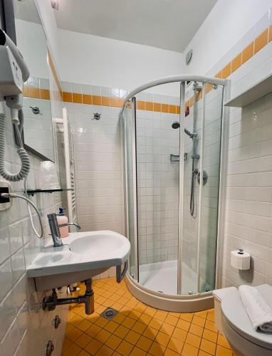 a bathroom with a shower and a sink and a toilet at Hotel Al Fogo in Bevazzana