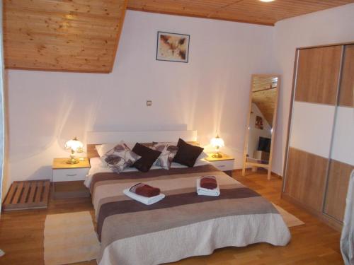 um quarto com uma cama grande com 2 mesas e 2 candeeiros em Apartments Pavlić em Rakovica