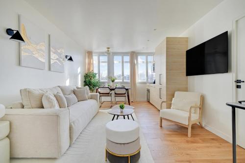 un salon blanc avec un canapé et une table dans l'établissement La Maison Bizot 52 T2 by Ecoflats, à Paris