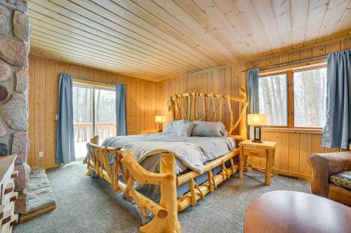 a bedroom with a wooden bed in a cabin at Less Than 1 Mi to Nubs Nob Ski Cabin with Sauna and Deck! in Harbor Springs