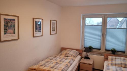 a bedroom with two beds and two windows at Wohnung in Datteln in Datteln