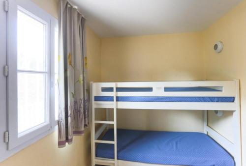 Ce lit superposé se trouve dans un dortoir doté d'une fenêtre. dans l'établissement Résidence le Hameau des Issambres - maeva Home - Studio 5 personnes - Sélection MAE-0621, aux Issambres