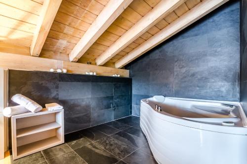 baño con bañera blanca y techo de madera en Hotel Nagusi en Murguía