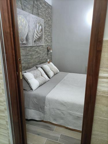 a bedroom with a bed with white sheets and pillows at Bed and breakfast Raggio di Sole in Iglesias